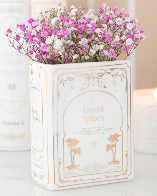 Rebel Romance Good Vibes White Book Shaped Vase styled with pink and white dried gypsophila flowers. A ceramic vase with a book-inspired design, ideal for book lovers and millennial homes embracing alternative and aesthetic décor.