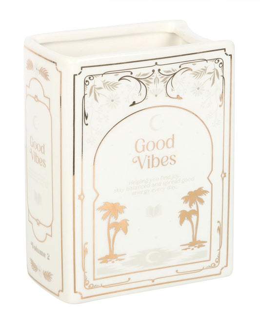 Side and front view of Rebel Romance Good Vibes White Book Shaped Vase with gold palm tree detail and the words “Good Vibes” on the cover design. A ceramic vase styled as an upright book, perfect for holding fresh or dried flowers in reading corners, shelves, or desks.