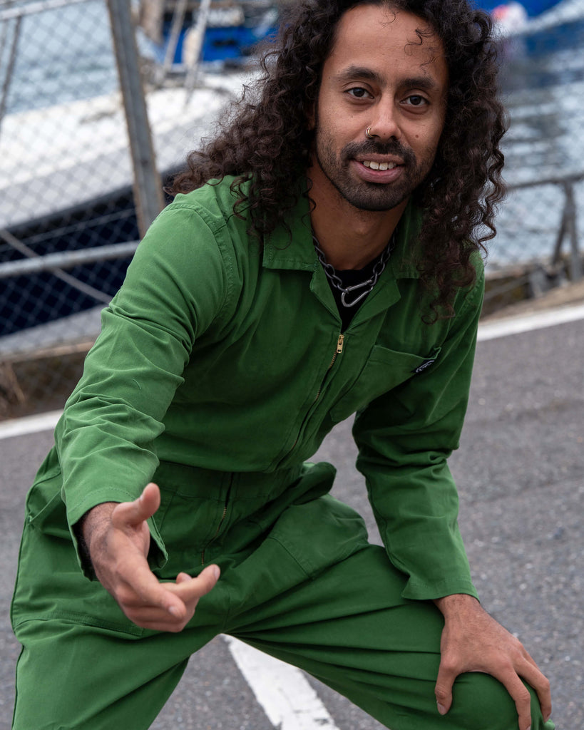 Richard crouching and smiling in the Forest Green Boiler Suit, showing the flexible and comfortable fit for movement.