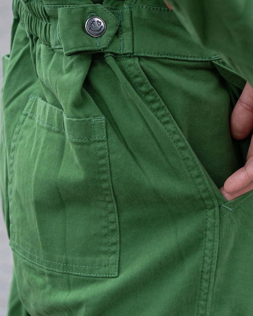 Close-up of pocket detail on the Forest Green Boiler Suit showing stitching and Rebel Romance happy-face button.