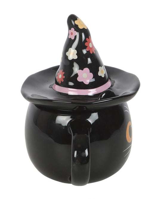 Side view of the Groovy Witch Cat Lidded Mug by Rebel Romance, showing its floral witch hat lid and curved black handle. The cat’s orange eyes and whiskers peek out from the front, making it a perfect spooky-season home accessory.