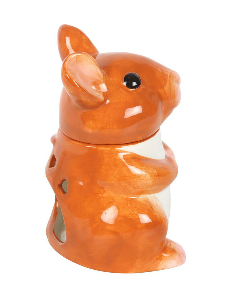 Side view of the mouse oil burner showing cut-out shapes in the back to allow light to shine through.