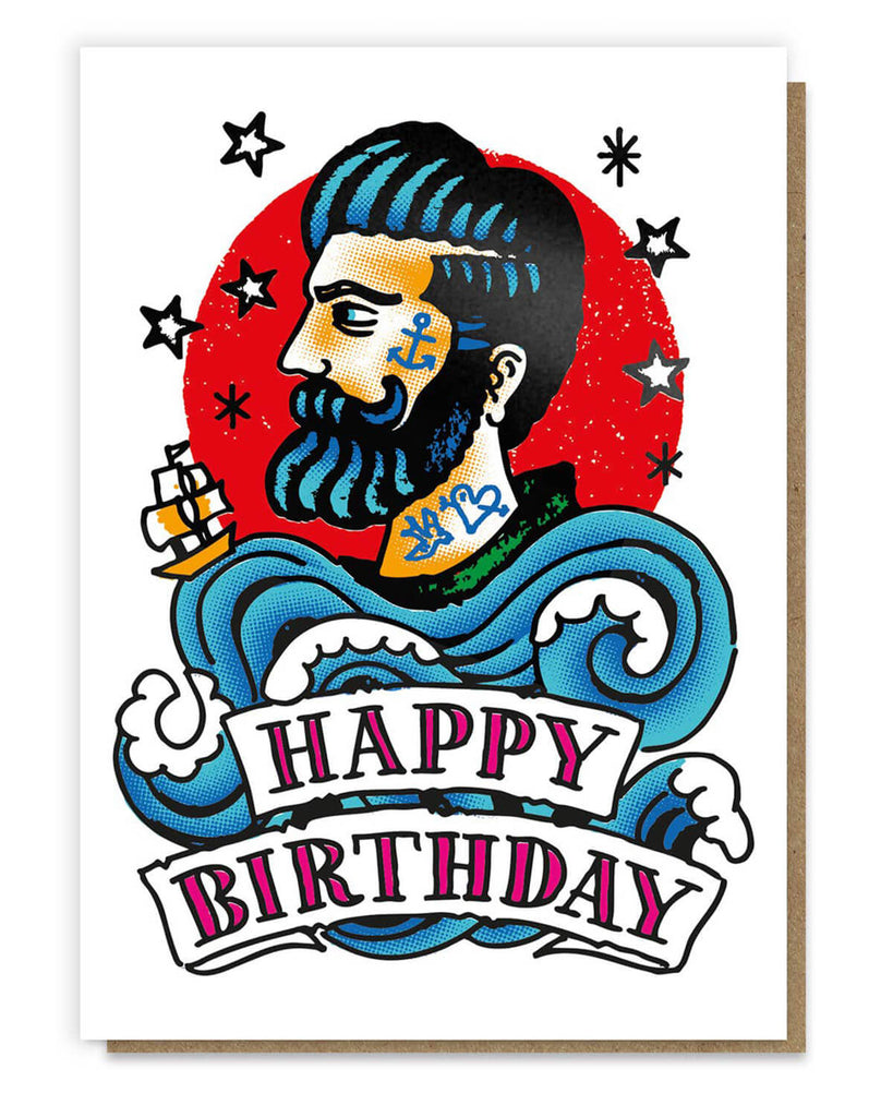 A vibrant greeting card featuring a bold illustration of a bearded sailor with nautical tattoos, set against a striking red circle. Waves and a ship surround him, with “Happy Birthday” displayed on a banner beneath, creating a dynamic tattoo-inspired design.