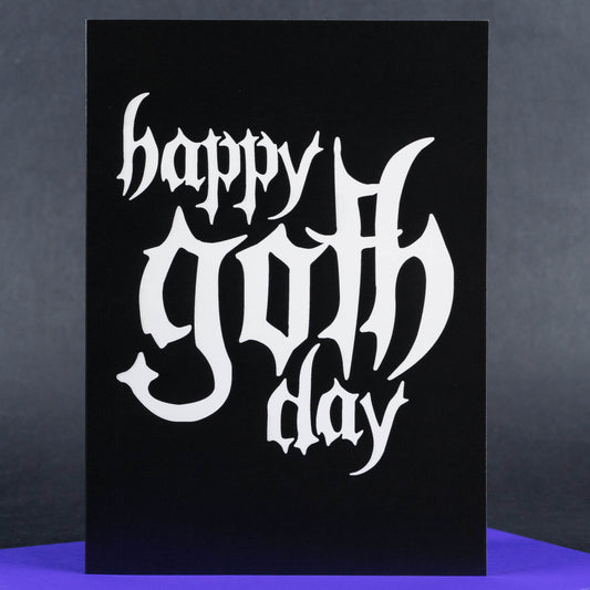 A striking minimalist greeting card with a black background and the words “Happy Goth Day” in dramatic, white gothic-style lettering. The bold contrast highlights the edgy aesthetic, perfect for celebrating in true goth fashion.