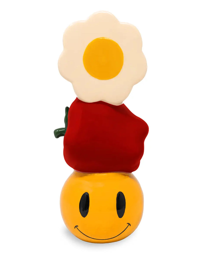 Front view of Rebel Romance’s Smiley Fun Vase showing a happy yellow smiley face base, red apple middle, and a daisy flower top. Eye-catching ceramic home décor for eclectic interiors, dopamine decorators, and millennial design lovers. Unique and joyful gift idea.