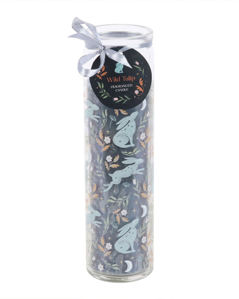 Midnight Hare Wild Tulip Tube Candle by Rebel Romance, showing the front label with a silver ribbon and tag. The candle has a navy background with moon-gazing hares, wildflowers, and crescent moons.