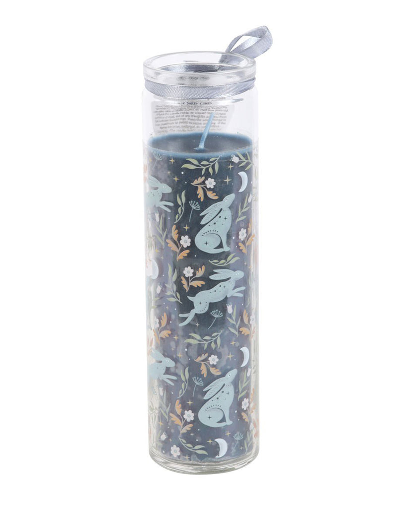 Full view of the Midnight Hare Wild Tulip Tube Candle by Rebel Romance. This tall glass prayer-style candle is adorned with mystical hare illustrations and wild tulip florals. A silver ribbon adds a finishing touch.