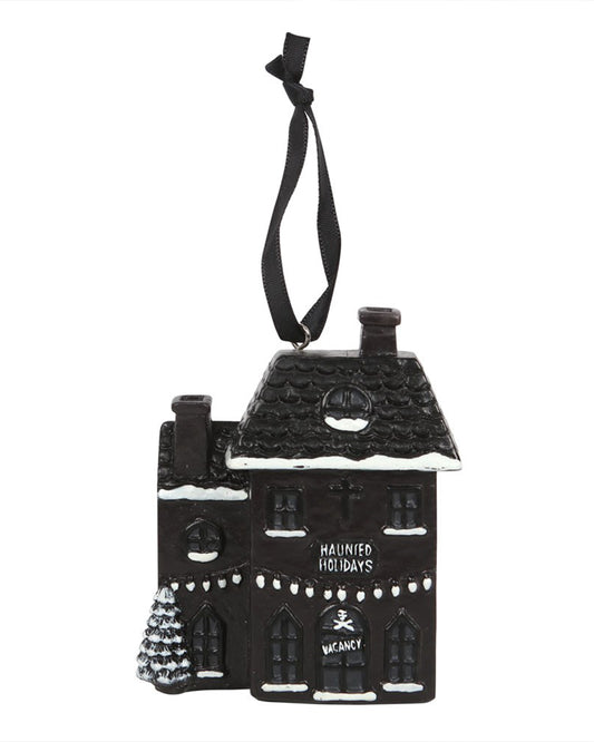 Front-facing view of Rebel Romance’s Haunted Holiday House resin decoration, with spooky festive details including snow accents, hanging lights, a cross, and gothic style “Haunted Holidays” text above a spooky skull-marked entrance.