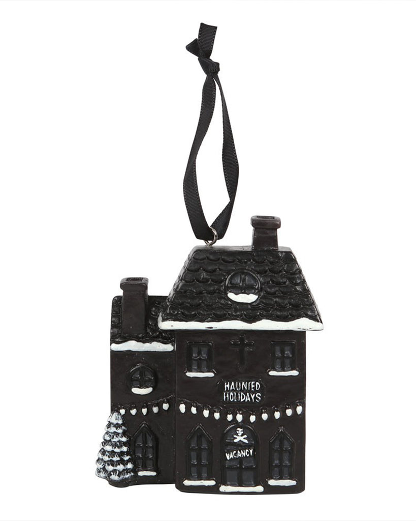 Front-facing view of Rebel Romance’s Haunted Holiday House resin decoration, with spooky festive details including snow accents, hanging lights, a cross, and gothic style “Haunted Holidays” text above a spooky skull-marked entrance.