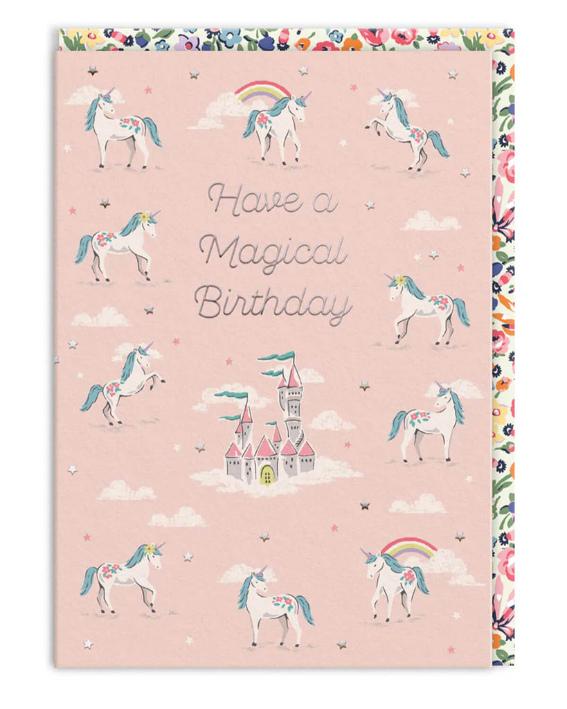 A6 birthday card featuring illustrated unicorns, a floating castle, rainbows, and pastel clouds on a pink background, with the message “Have a Magical Birthday.” Designed by Cath Kidston and stocked by Rebel Romance, this card features silver foil accents and a floral envelope. A perfect magical-themed birthday card for unicorn lovers and dreamers who adore whimsical, charming stationery.