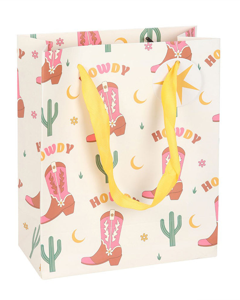 Rebel Romance medium gift bag featuring pink Western boots, cacti and moons, with bright yellow ribbon handles and a matching star gift tag for celebrations.