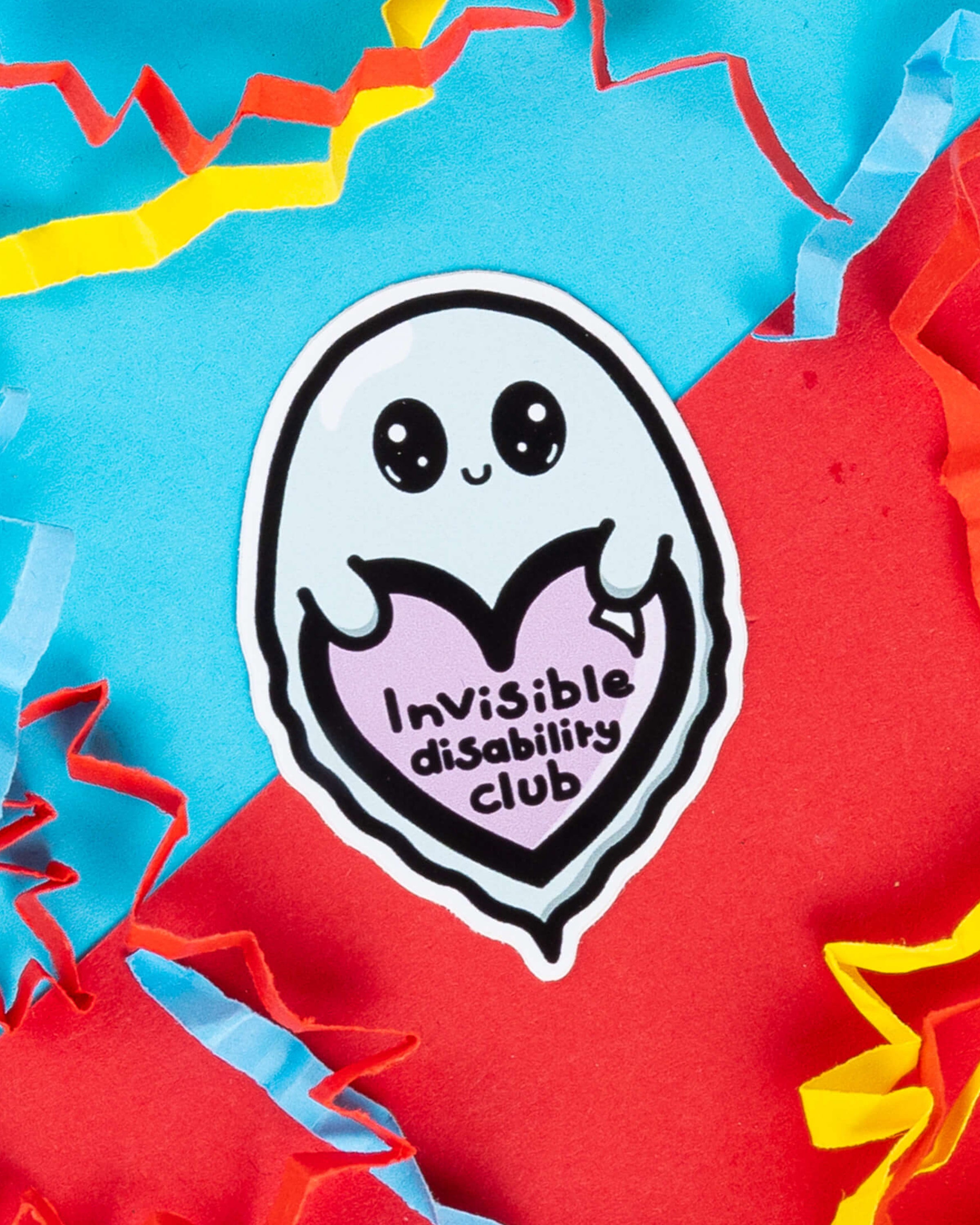Gloss vinyl sticker from Rebel Romance featuring a cute ghost holding a purple heart that says “Invisible Disability Club.” Designed by Innabox, this sticker raises awareness of invisible disabilities. It’s waterproof and perfect for decorating laptops, water bottles or journals. Set against a colourful red and blue background with paper confetti details. A thoughtful gift for disability pride and inclusion.