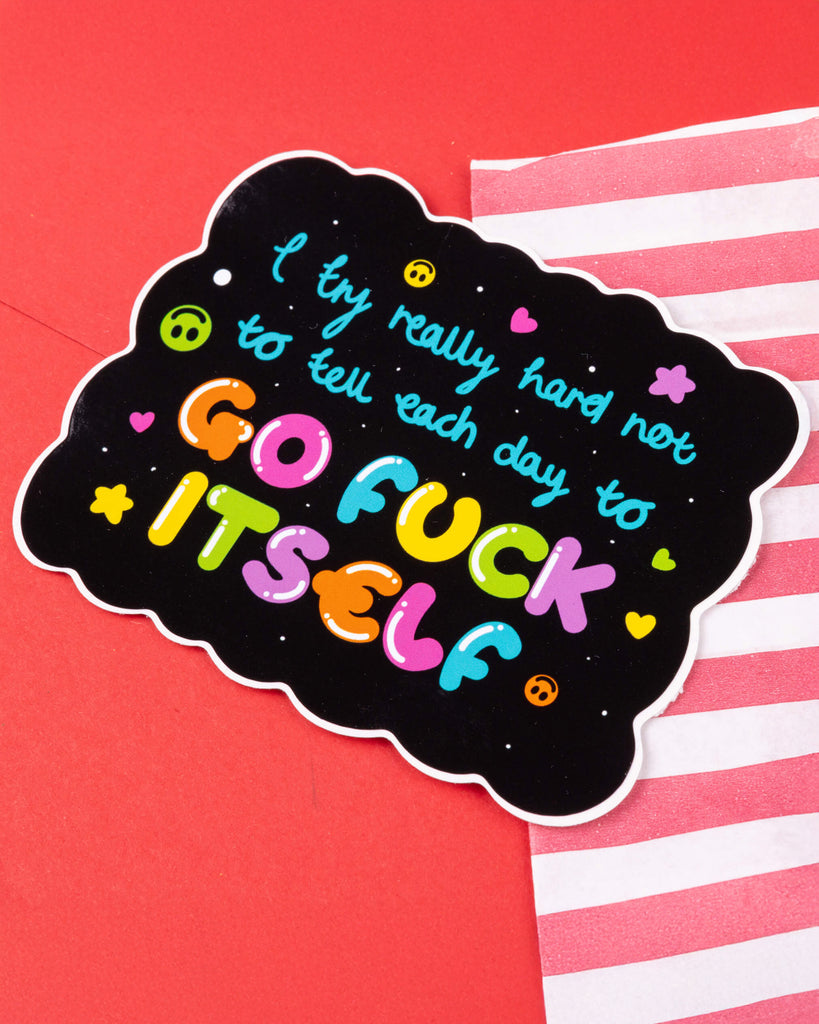 Rebel Romance I Try Really Hard Large Sticker by Innabox, featuring a bold, rainbow text on a custom-shaped black background with colourful lettering that reads: “I try really hard not to tell each day to go f*** itself.” Fun and sweary motivational vinyl sticker for millennials who love alternative style and chronic illness awareness. Glossy, waterproof, and suitable for indoor and outdoor use.