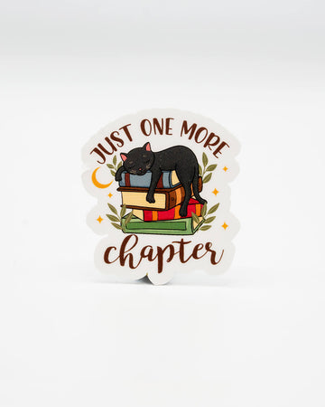 Cosy die-cut vinyl sticker featuring a black cat snoozing on a stack of colourful books, surrounded by leaves and stars. Text reads “Just One More Chapter” in a warm, bookish font. A perfect gift for readers and cat lovers alike. Designed by Rebel Romance, a small UK business known for alternative style, slow fashion, and cute, millennial-friendly gifts and accessories.