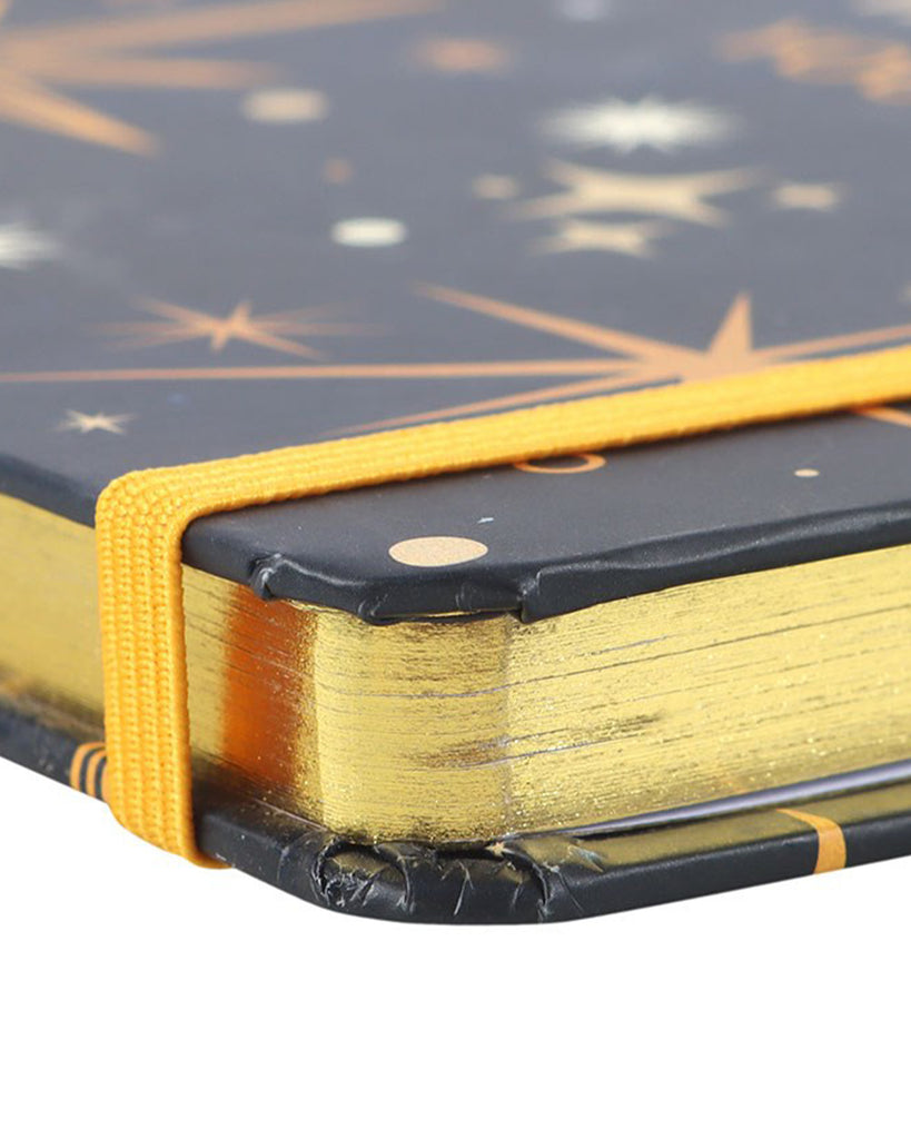 Close-up of a notebook with star pattern and gold binding on a white background