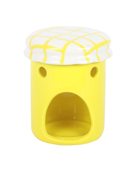 Close-up of the Rebel Romance lemon curd jar oil burner and wax warmer with its lid on, featuring a white top with a yellow criss-cross pattern and a cut-out section at the base for a tealight. Quirky and functional homeware that doubles as a fun décor piece.