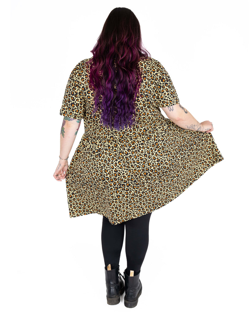 Back view of Luisa wearing the Rebel Romance Classic Leopard Print Stretch Smock Dress. The soft, stretchy fabric and oversized fit give the dress a flowy, flattering shape. Luisa (she/her) is 5'6", a high street size 22/24, and wears a size 24. Styled with black leggings and chunky boots. Rebel Romance is a small UK brand celebrating alternative, ethical fashion for millennials.