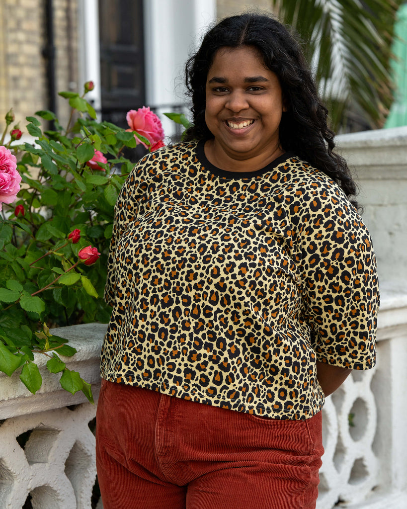 Vidhya models the Rebel Romance Classic Leopard Cropped Boxy Tee with a bright smile, paired with rust-red cords. This boxy animal print tee is designed by Rebel Romance, a UK slow fashion brand embracing bold, inclusive style.