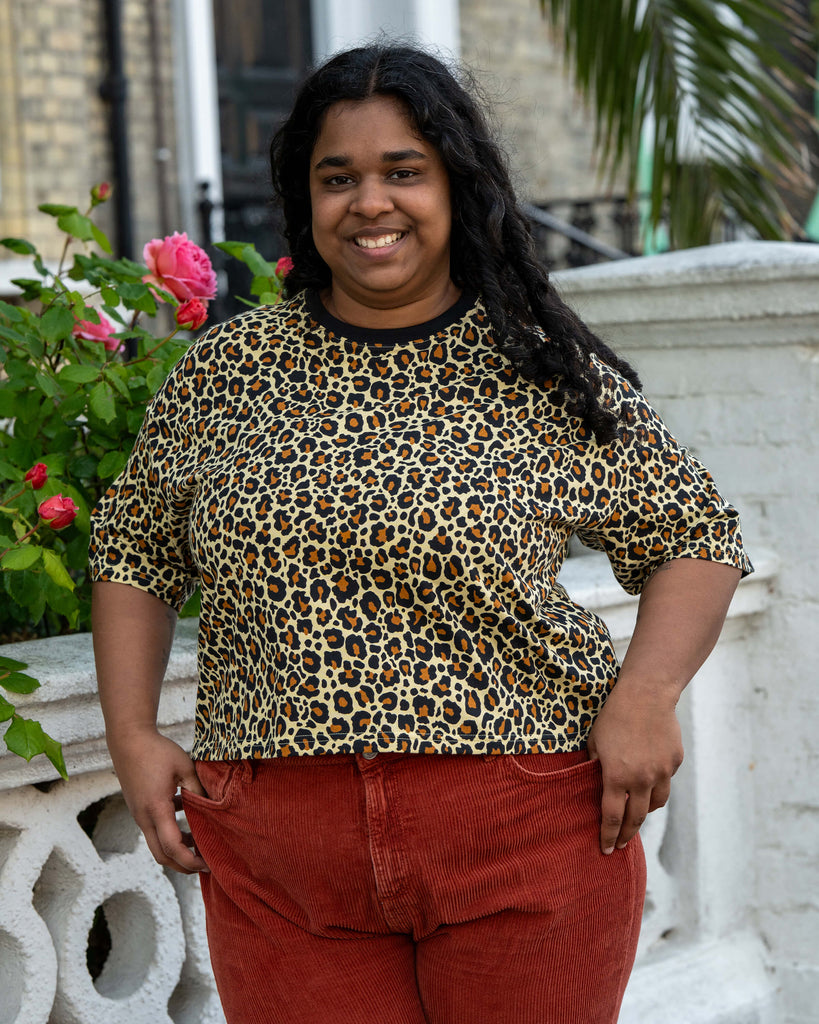 Vidhya wears the Rebel Romance Classic Leopard Cropped Boxy Tee, a fierce short sleeve top with bold animal print and relaxed fit. Styled with burnt orange corduroy trousers, this tee is part of Rebel Romance’s ethical fashion range for alternative dressers.