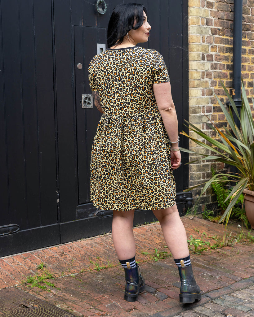 Back view of the leopard print smock dress showing the gathered waist and relaxed silhouette on Carmen.