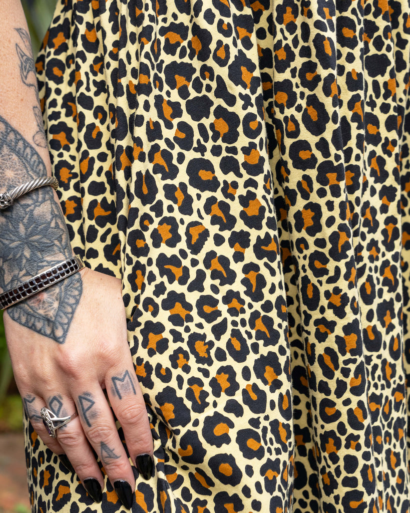 Close-up of Carmen’s hand showing the leopard print fabric and side pocket detail of the Rebel Romance smock dress.