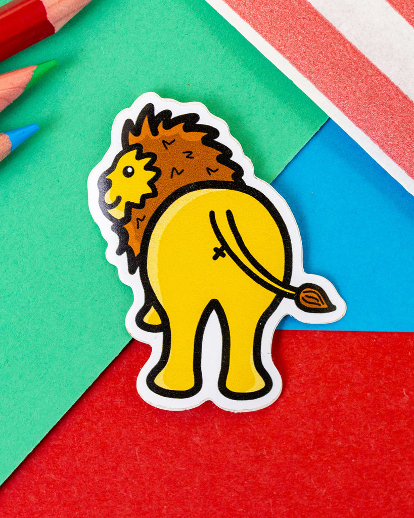 Glossy vinyl Lion Bum Sticker designed by Innabox, available from Rebel Romance. Features a funny cartoon lion facing backwards with its bum on display. Bright yellow and brown design, ideal for laptops, water bottles, notebooks and more. Perfect for millennial sticker collectors and lovers of quirky, alternative accessories. Waterproof and suitable for indoor or outdoor use.