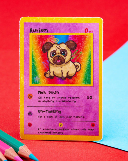 A colourful autism-themed trading card-style sticker featuring a cute cartoon pug against a rainbow puzzle background. The sticker reads “Autism” and includes playful traits like “Melt Down” and “Un-Masking.” Designed by Innabox and sold by Rebel Romance, a UK indie business celebrating neurodivergence and alternative aesthetics