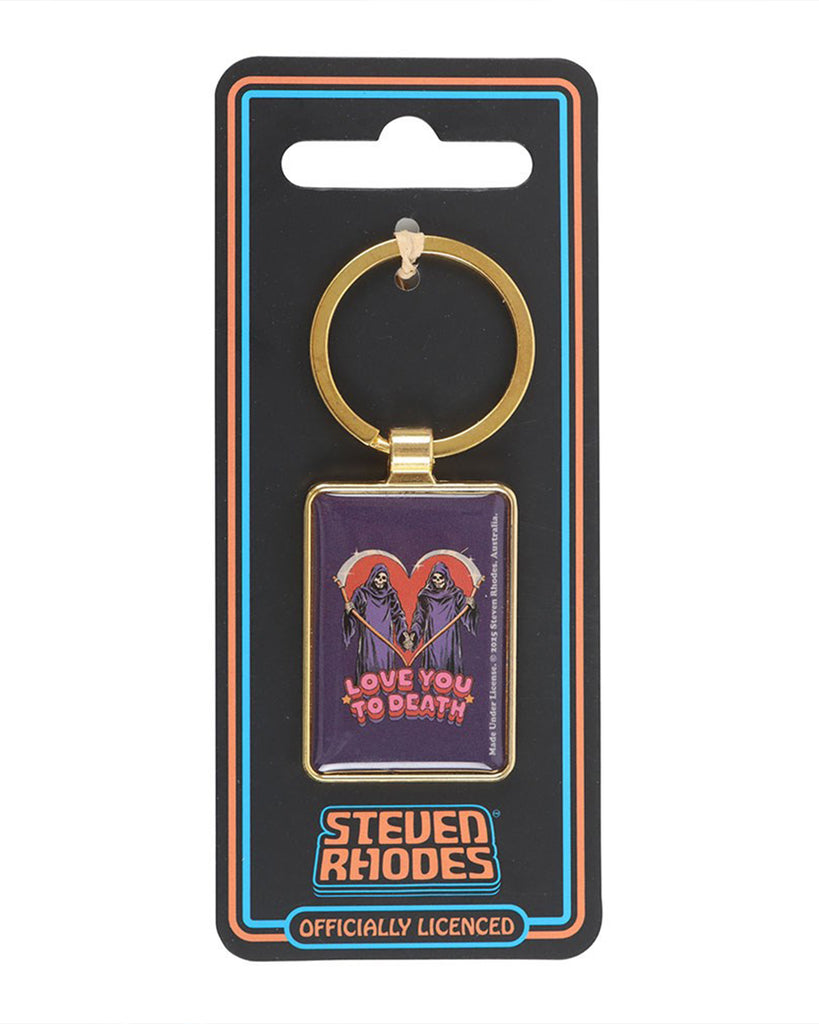 Rebel Romance Steven Rhodes enamel keyring packaged on branded black and neon backing card. The “Love You To Death” design shows two grim reapers with scythes forming a red heart above retro text. Alternative gothic gift for millennial style lovers.