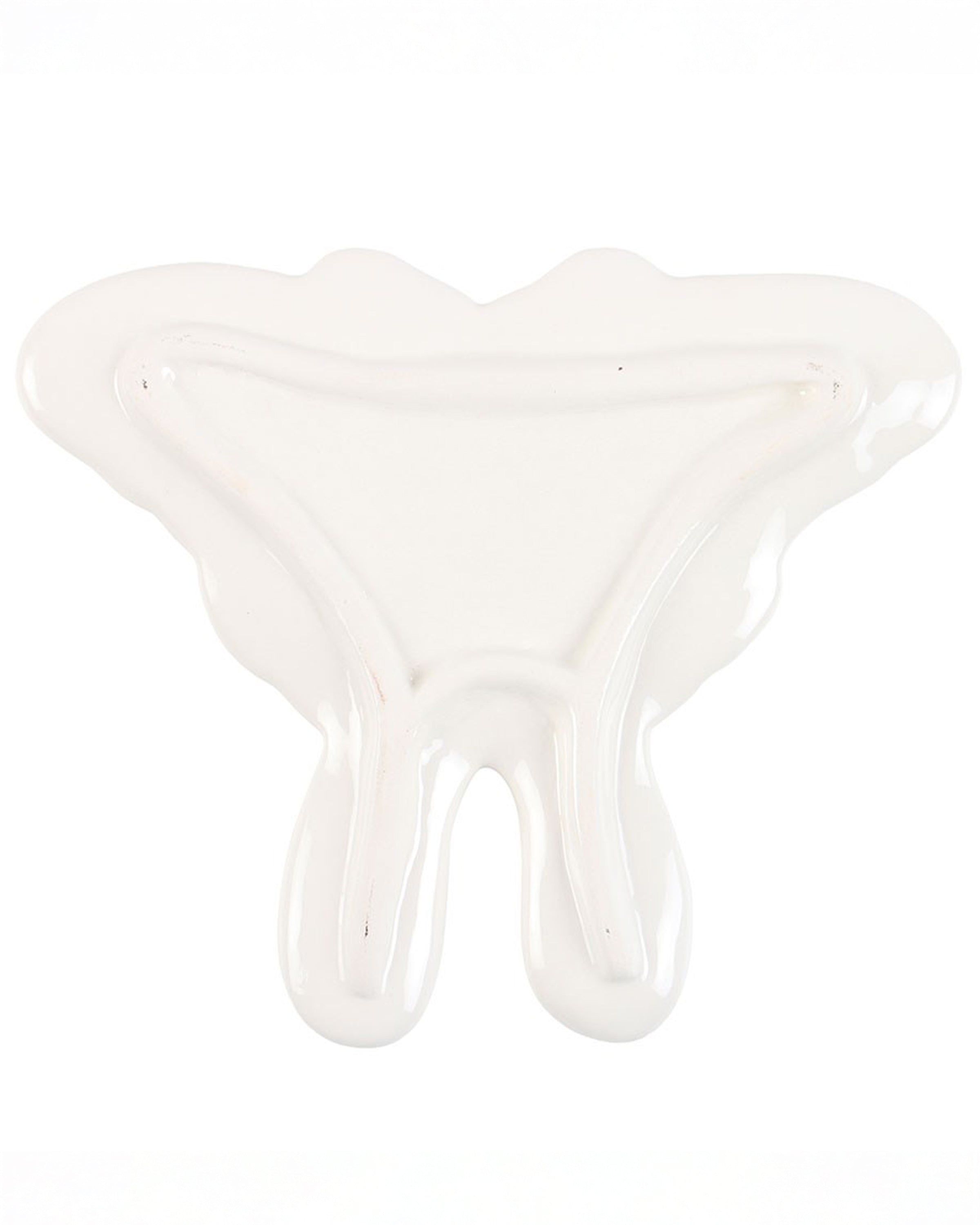 The underside of the Rebel Romance luna moth ceramic trinket dish, showing the smooth white glaze and subtle raised edges that keep small treasures secure.