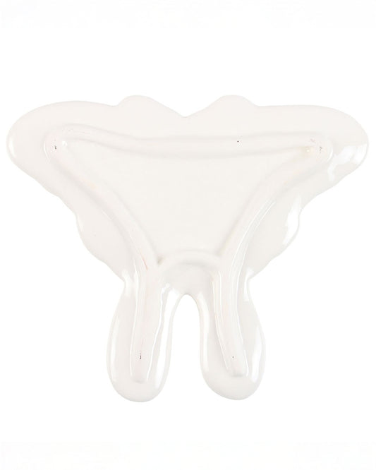 The underside of the Rebel Romance luna moth ceramic trinket dish, showing the smooth white glaze and subtle raised edges that keep small treasures secure.