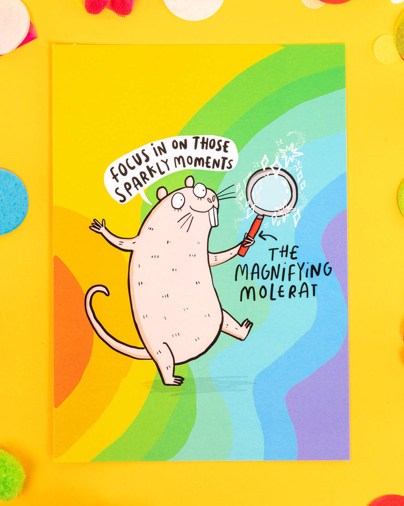 A rainbow A6 postcard featuring a cute illustrated naked mole rat holding a magnifying glass with the phrase “Focus on those sparkly moments.” Designed by Katie Abey, this colourful and uplifting card is perfect for millennials who love alternative stationery, dopamine dressing, and playful reminders to stay positive.