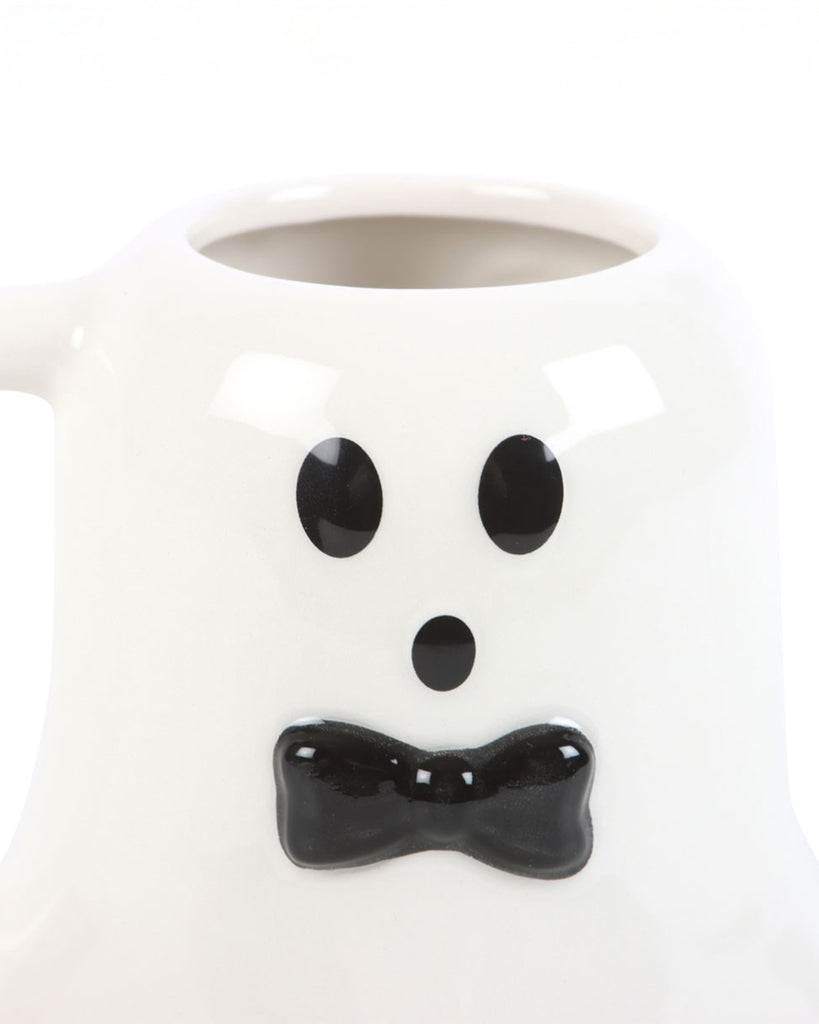 Close-up of the mug's face, highlighting the glossy black facial features and bow tie on the white ceramic surface.