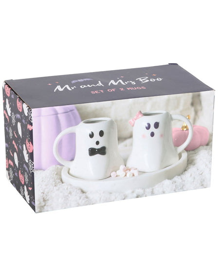 A rectangular box displaying the Mr and Mrs Boo ghost mug set from Rebel Romance. The wedding gift packaging shows two ghost-shaped mugs, one with a black bow tie and the other with a pink bow, placed on a white tray with pastel pink and purple accents in the background. The box features spooky and cute Halloween-themed designs on the side.