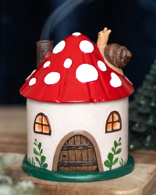 The mushroom house incense burner in use, with scented smoke flowing from its chimney. Creates a magical fairytale vibe. Sold by Rebel Romance, a UK alternative lifestyle brand for magical millennials.