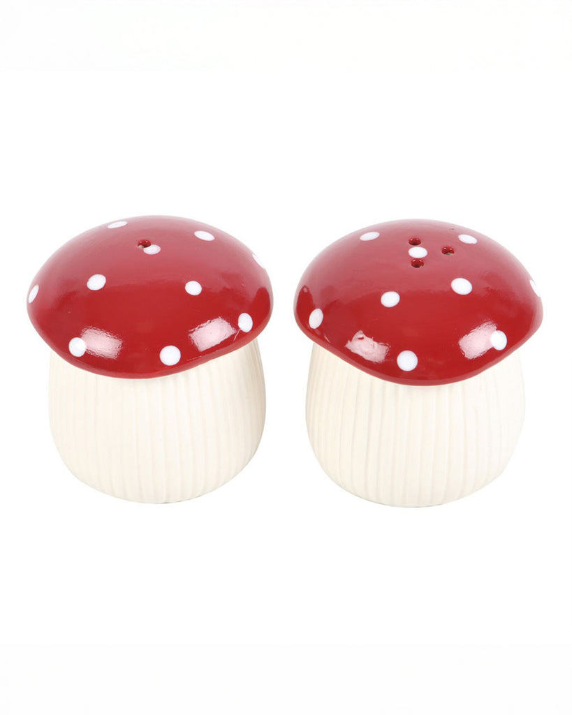Pair of mushroom-shaped salt and pepper shakers with red caps and white spots, designed by Rebel Romance. Their ribbed white stalks and whimsical shape give a magical woodland vibe.