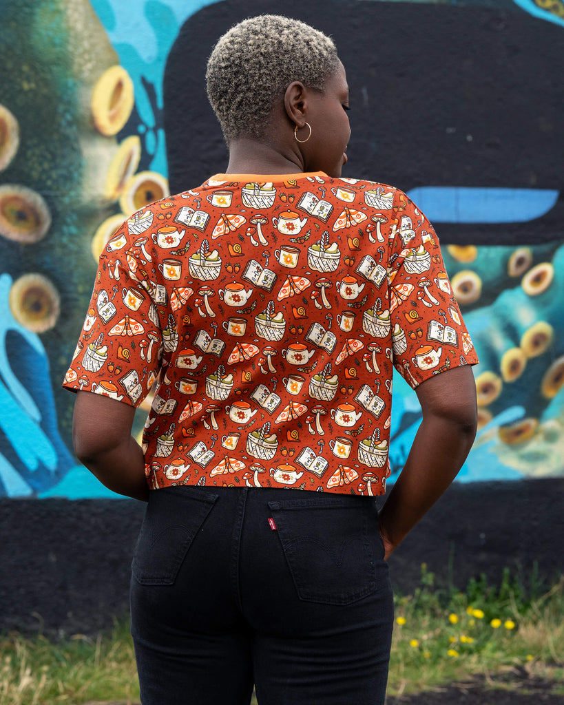 Back view of the Mushroom Tea Party cropped tee by Rebel Romance, featuring a detailed all-over print of autumnal cottagecore motifs.