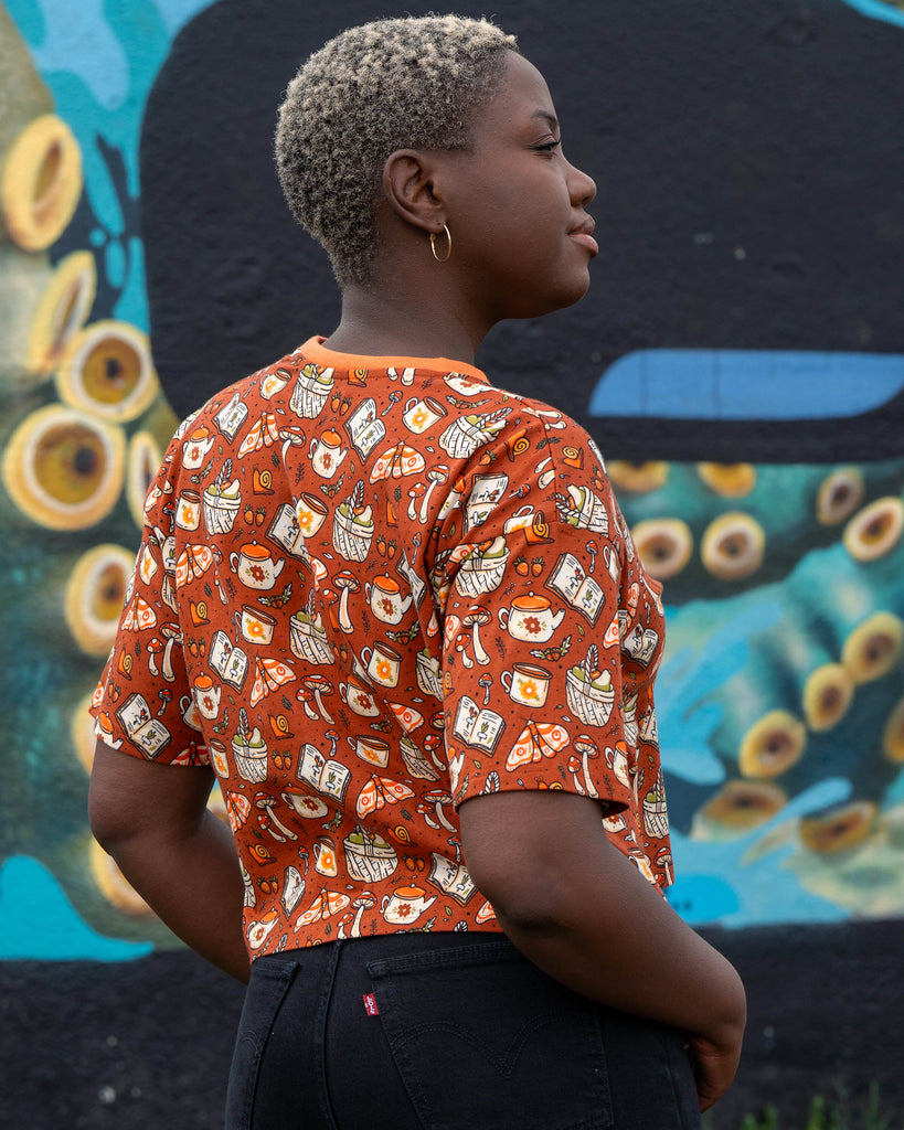 Back view of the Mushroom Tea Party cropped tee by Rebel Romance, featuring a detailed all-over print of autumnal cottagecore motifs.