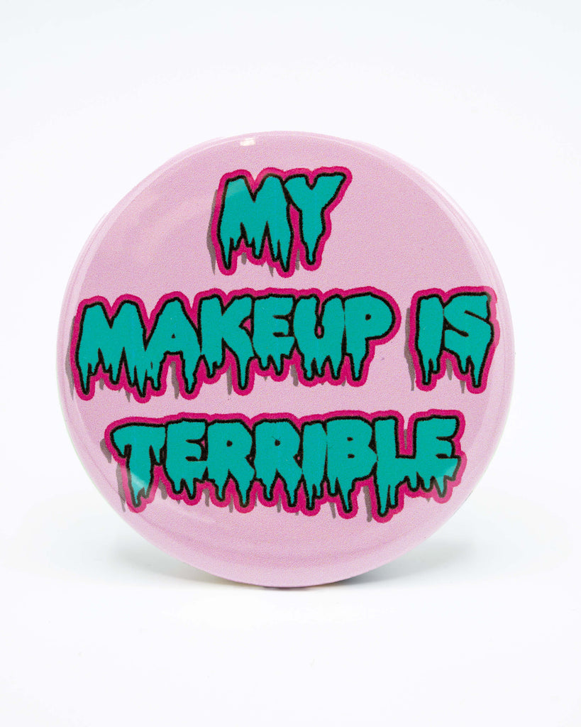 Circular pastel pink pocket mirror with blue writing that reads 'My Makeup is Terrible'. A drag race, drag queen inspired retro design from Bite Your Granny.