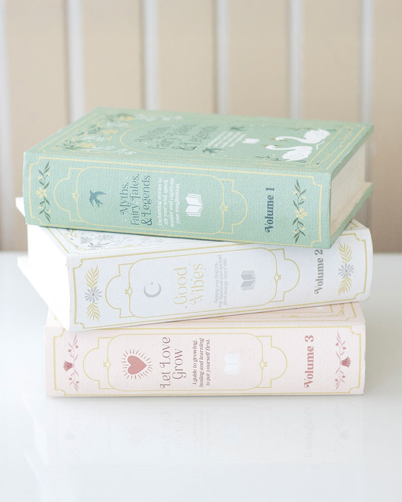 Stack of three Rebel Romance book shaped storage boxes styled as vintage hardbacks, in pastel green, cream and blush pink with elegant foil details. The top book, titled Myths, Fairy Tales & Legends, is a clever hidden storage box, perfect for blending into bookshelves and adding whimsical home décor.