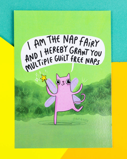 A green postcard of a cat with fairy wings and wand saying, I am the nap fairy and I hereby grant you multiple guilt free naps. 