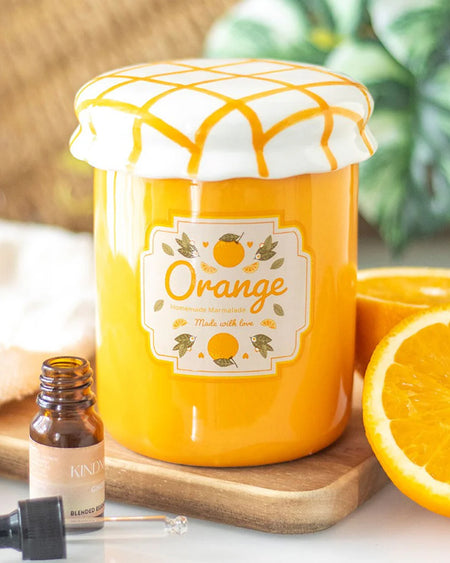 The orange marmalade oil burner styled with an essential oil dropper and fresh orange slices. The vibrant citrus colours and vintage-inspired aesthetic make it a standout home décor piece.