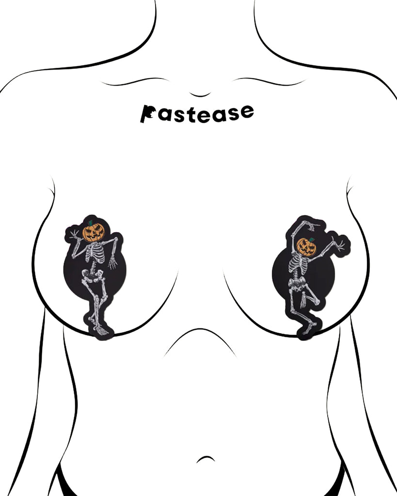 Dancing Skeletons Pasties with Pumpkin Heads Spooky Scary Skeletons nipple covers on a white background. One of the skeletons is dancing with one leg in the air and both arms up, while the other is dancing with arms bent and legs together. Both skeletons have orange spooky faced pumpkin heads.