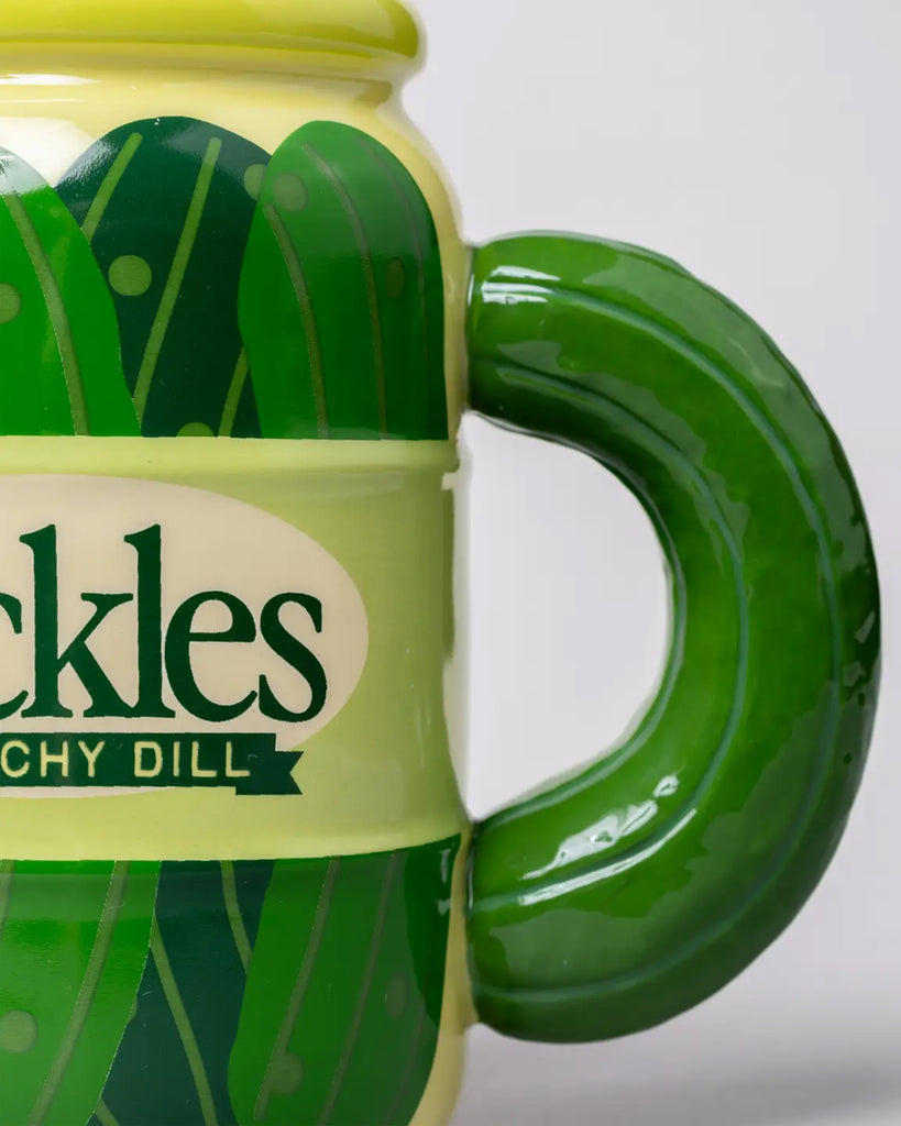 Close-up of the pickle handle on the novelty mug from Rebel Romance, showcasing its shiny ceramic texture and deep green tones. A fun gift for anyone with a tangy sense of humour.