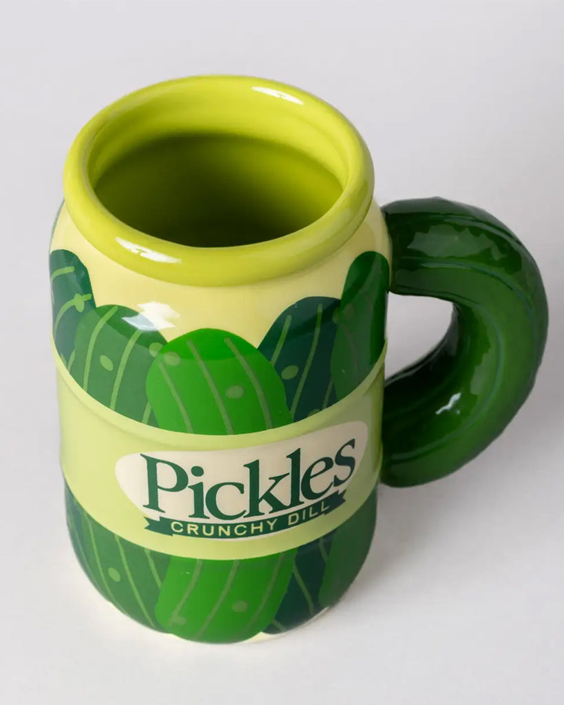 Top-down angled view of the pickle jar ceramic mug from Rebel Romance. The mug features glossy details and a realistic green pickle handle. A cheeky and cheerful mug perfect for your kitchen or desk.