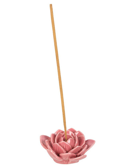 A close-up of a pink lotus-shaped incense burner, designed for meditation and relaxation, with an incense stick releasing fragrant smoke.
