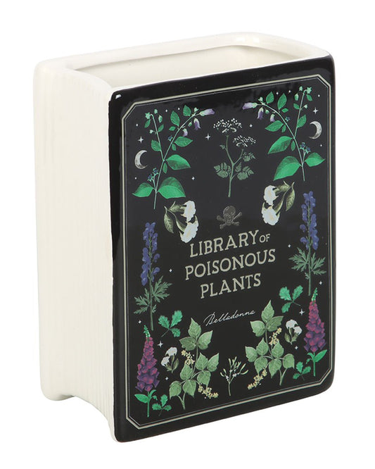Front-facing view of the Rebel Romance ceramic Poisonous Plants Book Vase. Decorated with detailed illustrations of toxic flora on a black book-style design with the title "Library of Poisonous Plants". A quirky gothic home accessory for bookworms and plant lovers.