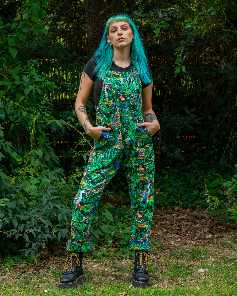 Model Claudia wears the Rebel Romance Pond Birds Dungarees, a colourful green wetland design with detailed birds and flowers. These dungarees are made from stretch twill with a relaxed unisex fit, ethically produced and perfect for dopamine dressing.
