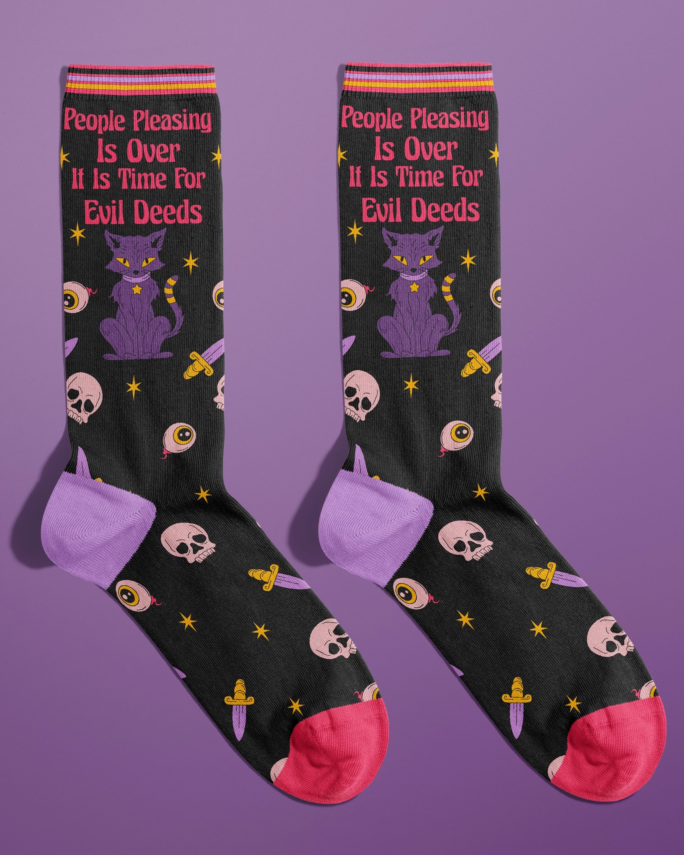 Flat lay of novelty black crew socks with red toes and purple heels, featuring bold pink text that reads 