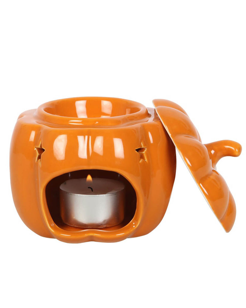 Side view of the pumpkin burner with the lid off, showing a lit tealight and the oil dish above.