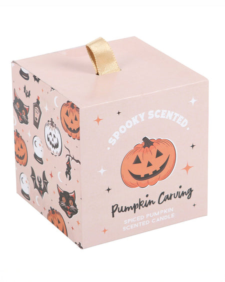 The front of the Pumpkin Carving candle’s packaging, featuring a peach-coloured box with a cute jack-o'-lantern illustration and a fabric loop for easy opening.